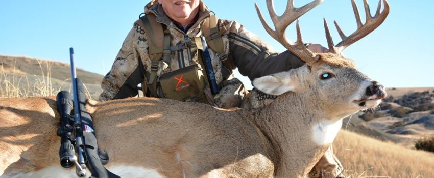 The author smiles behind his great heavy-massed Dakota buck taken with a Savage Model 16 and Fusion 6.5 Creedmoor ammo.