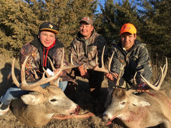 Isaac Hawk (L) Farley Hawk (Dad) and Max Hawk (R) smile behind their great whitetail deer.