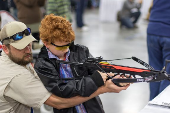 A youngster tries out a Daisy crossbow at the National Wild Turkey Convention.