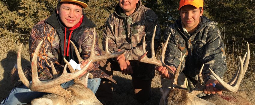 Isaac Hawk (L) Farley Hawk (Dad) and Max Hawk (R) smile behind their great whitetail deer.